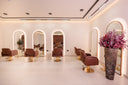 Snob Salon interior with illuminated arched mirrors, warm cream walls and terracotta chairs